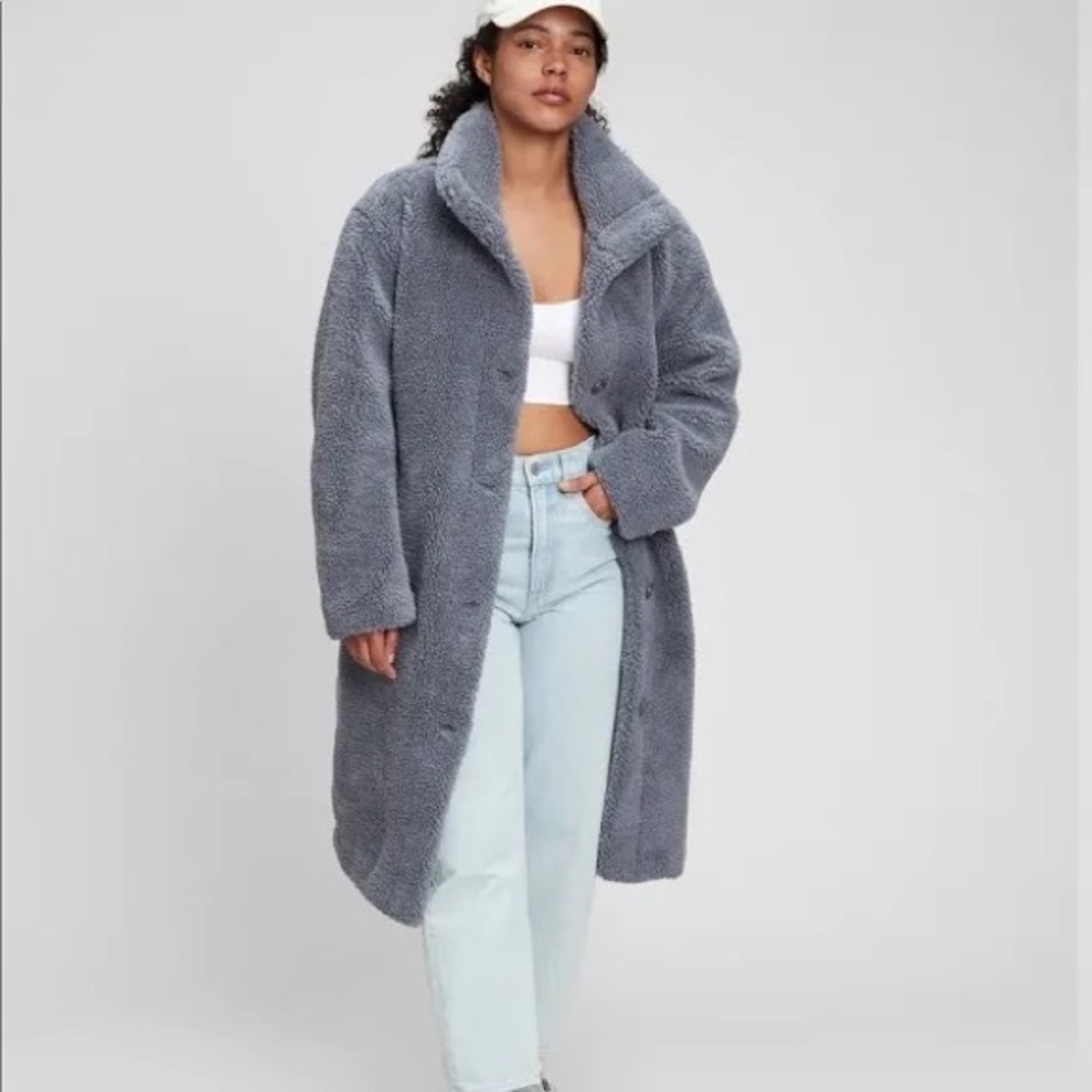 Cozy sherpa coat. Funnel neck. Long sleeves. Button front. Front slant pockets.